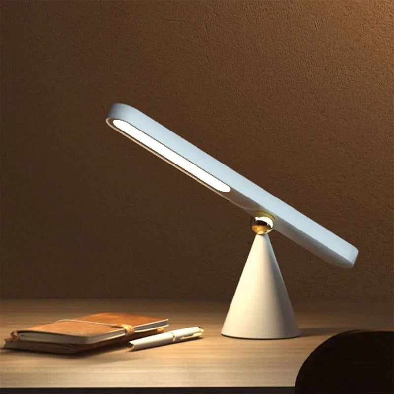 White geometric desk lamp with magnetic base mounted on a metal wall surface.