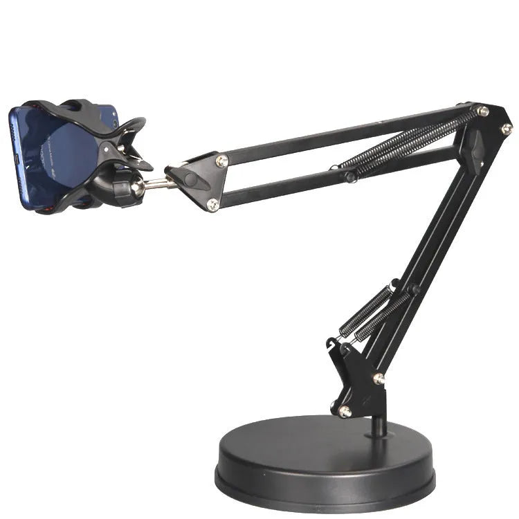 Black universal phone stand with long adjustable metal arm and heavy round base on a desk