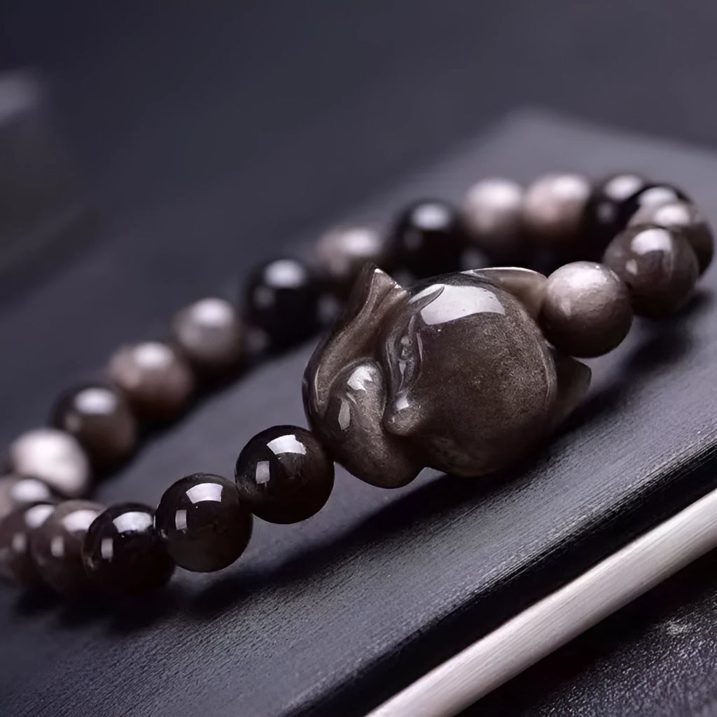 Obsidian fox single ring bracelet with 8mm black stone bead and silver charm on elastic cord.