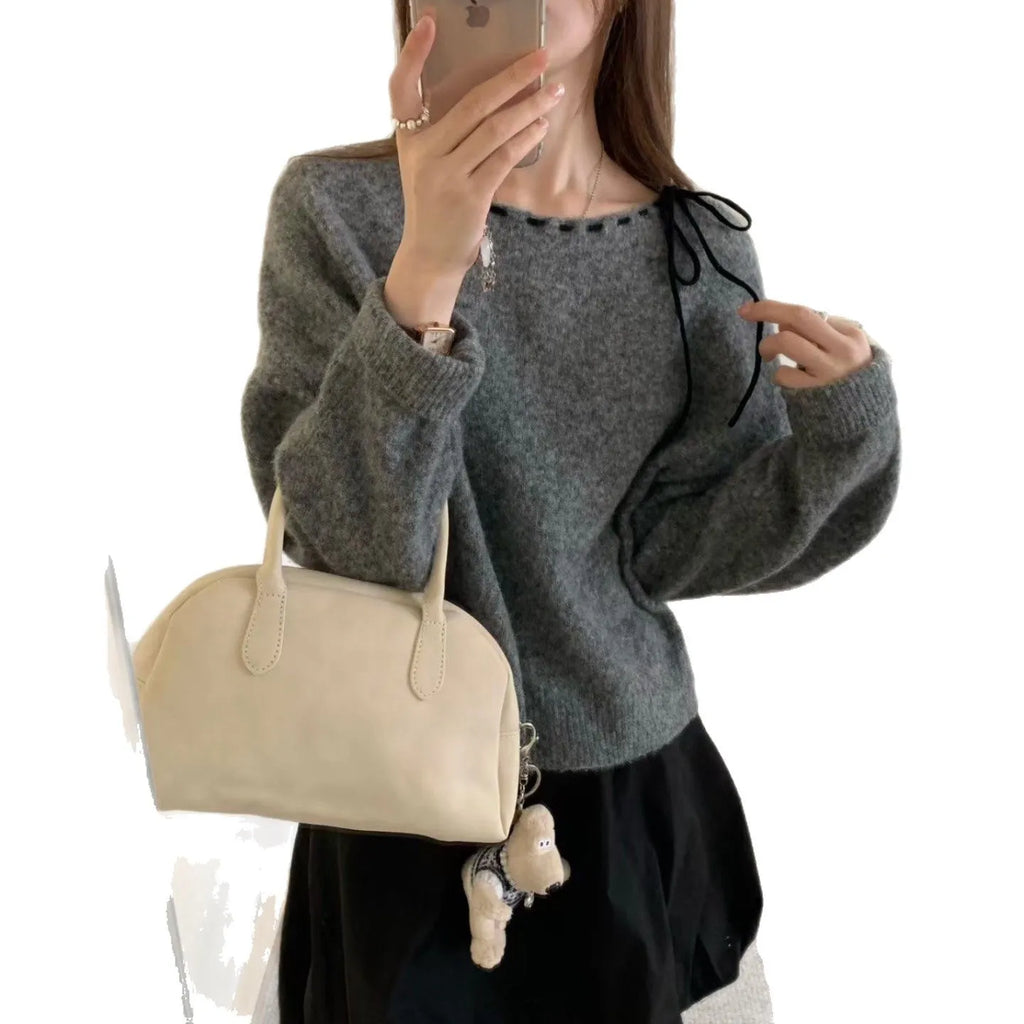 Grey and black versions of a women's loose-fitting pullover jumper made from soft knit fabric.