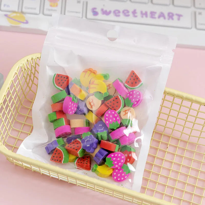 Sealed plastic bag containing 50 small cartoon-themed erasers in shapes like fruits, animals, and Christmas symbols.