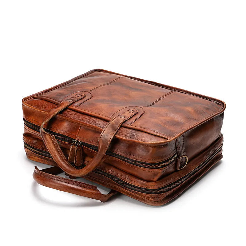 Vintage brown leather men's briefcase with a soft handle, shown open to reveal internal organiser pockets.