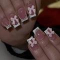 Short white French tip press-on nails with a cute pink bow design and a tulip pattern on a blush base.