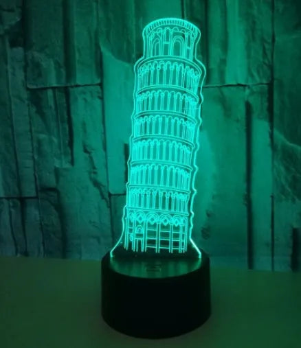 3D laser-cut Leaning Tower of Pisa nightlight glowing blue on a black base with a remote control.