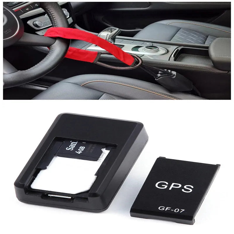 Small black magnetic GPS tracker device next to a USB charging cable on a table.
