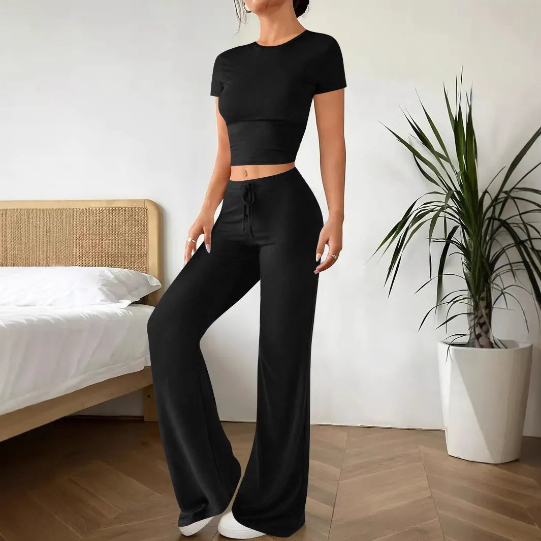 Black high-waist polyester trousers and matching short-sleeve t-shirt laid flat as a two-piece suit set.