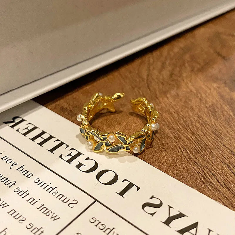 Creative butterfly design women's ring in copper with oil drip finish, showing an open loop style.