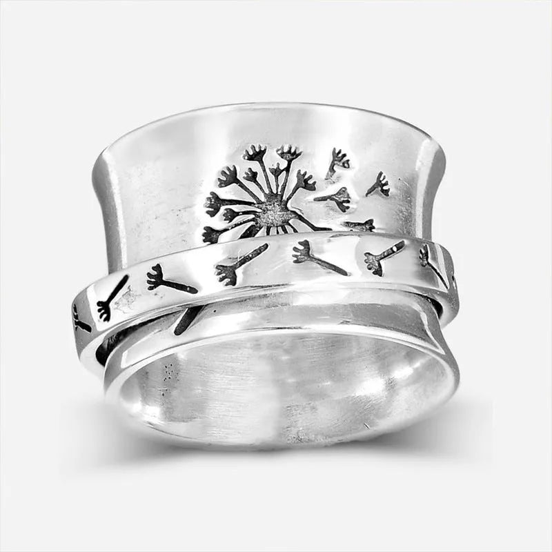 Silver rotating flower ring with movable petals on a finger, showing the kinetic jewellery design