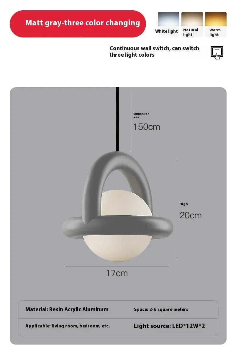 Matte black hanging line lamp with a long black cord suspended above a bedside table.