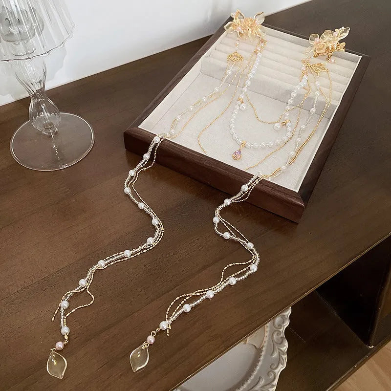 Gold-coloured acrylic hairpin with a long tassel and diamond-treated flower decoration.