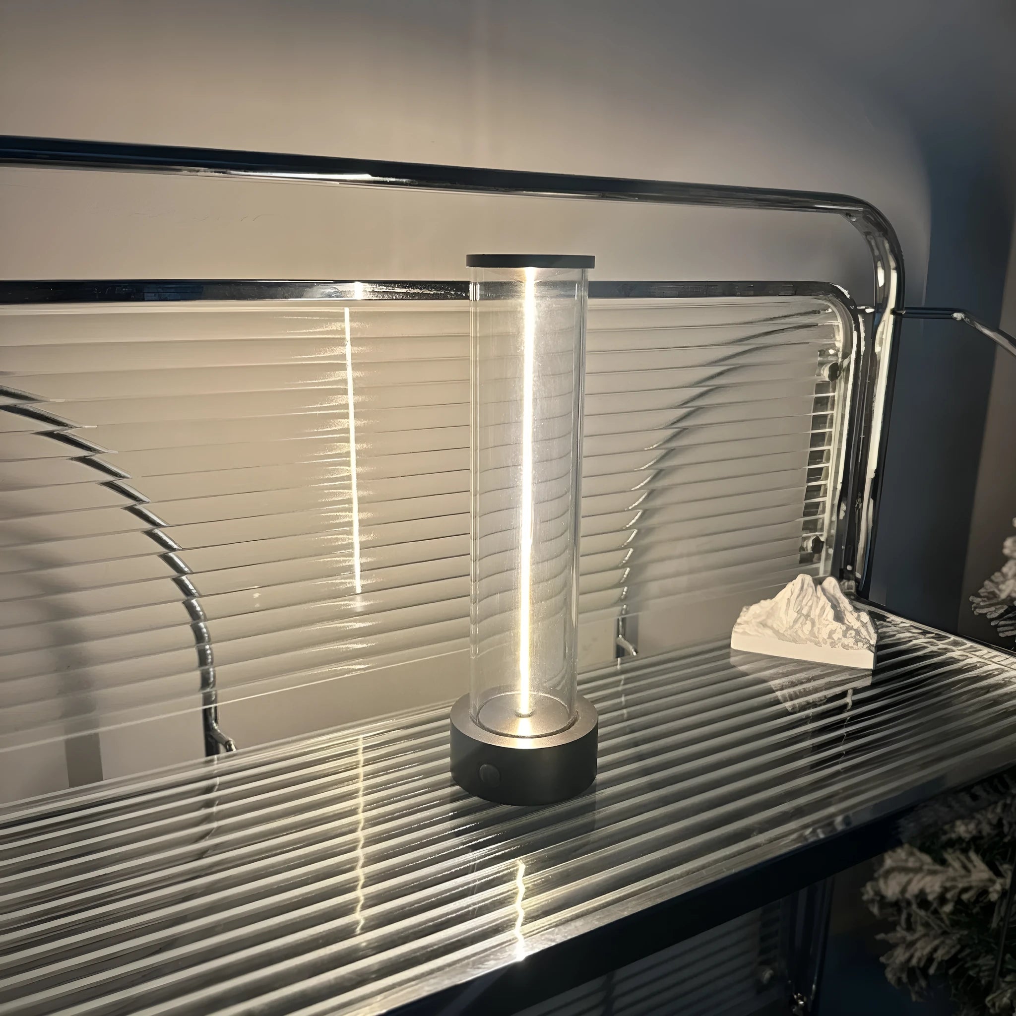 Modern glass USB LED night light with magnetic strip on a metal surface.