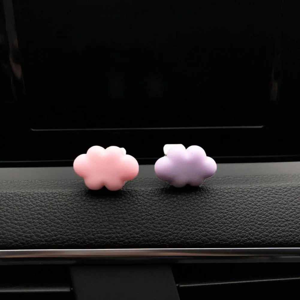 Resin cartoon car fragrance clip in pastel colours on a car air vent.