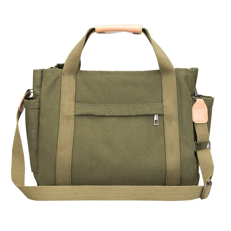 A horizontal square canvas tote bag in army green with a cross-body strap and visible sewing lines.