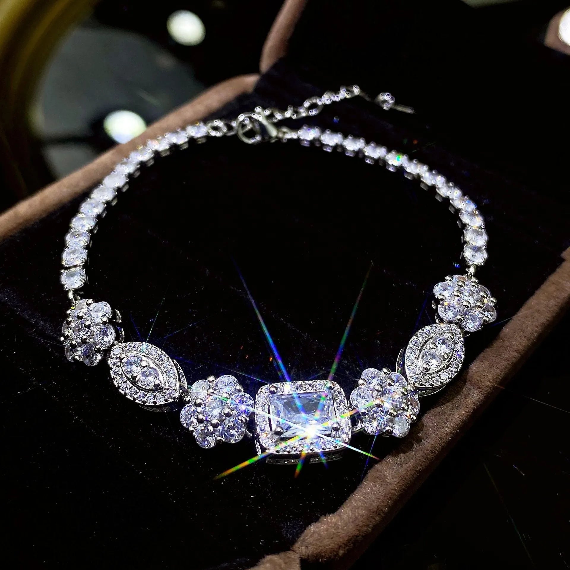 Women's geometric silver bracelet with inlaid zircon stones on a wrist, showing adjustable chain.