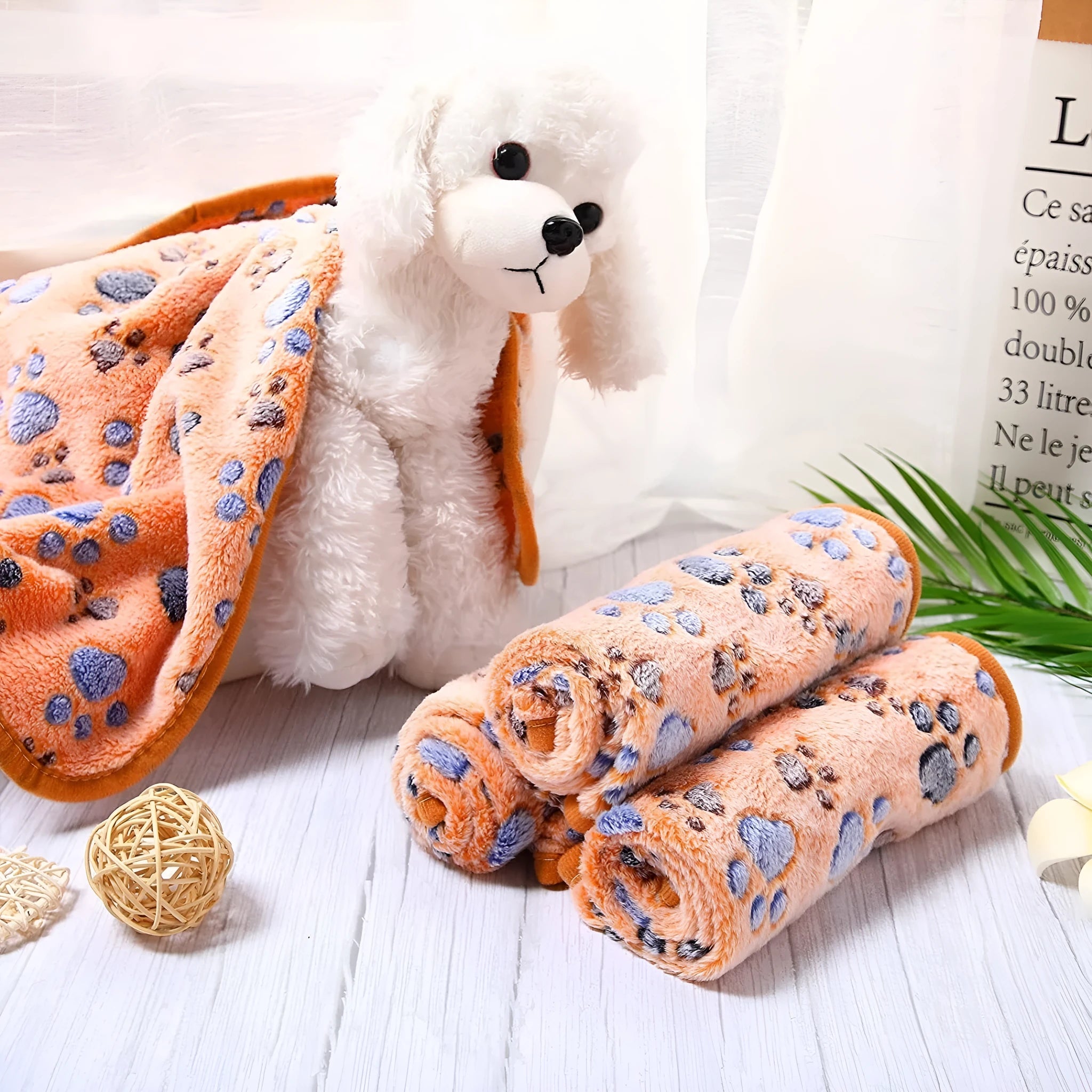 Coral fleece pet blanket with dog paw print pattern shown in beige colour, lying flat to show size