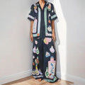 Black women's co-ord set with cartoon animation print, featuring a cardigan and trousers.