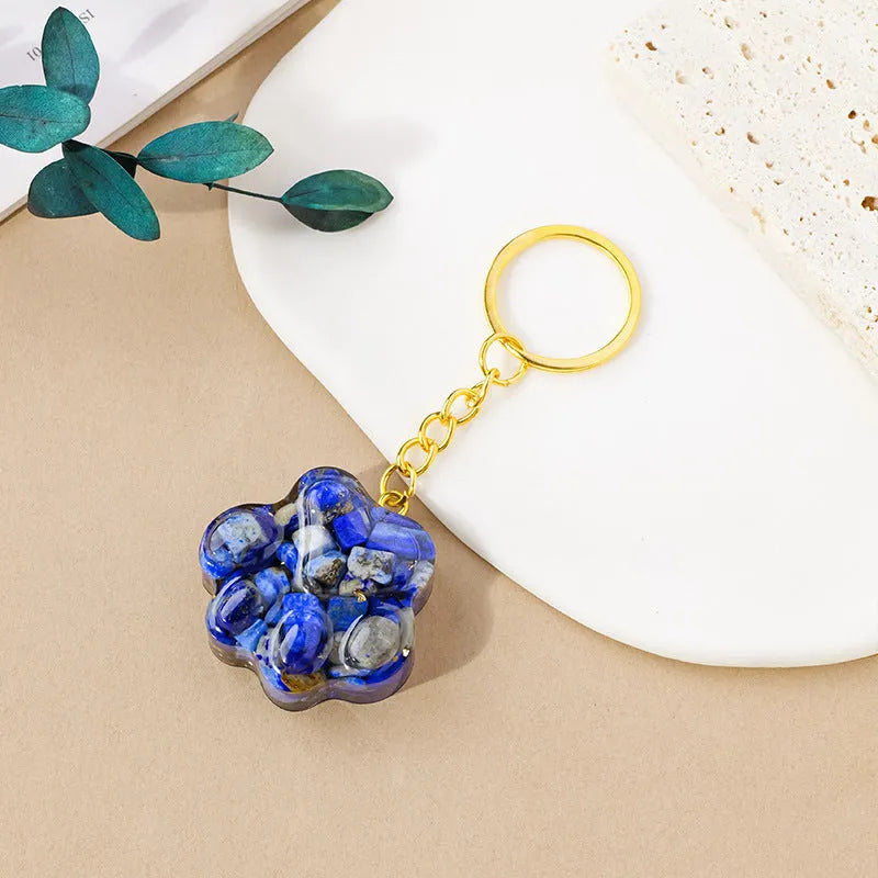 Hand-finished natural crystal cat's paw keychain pendant on a metal ring, showing detailed carving and polished stone surface.