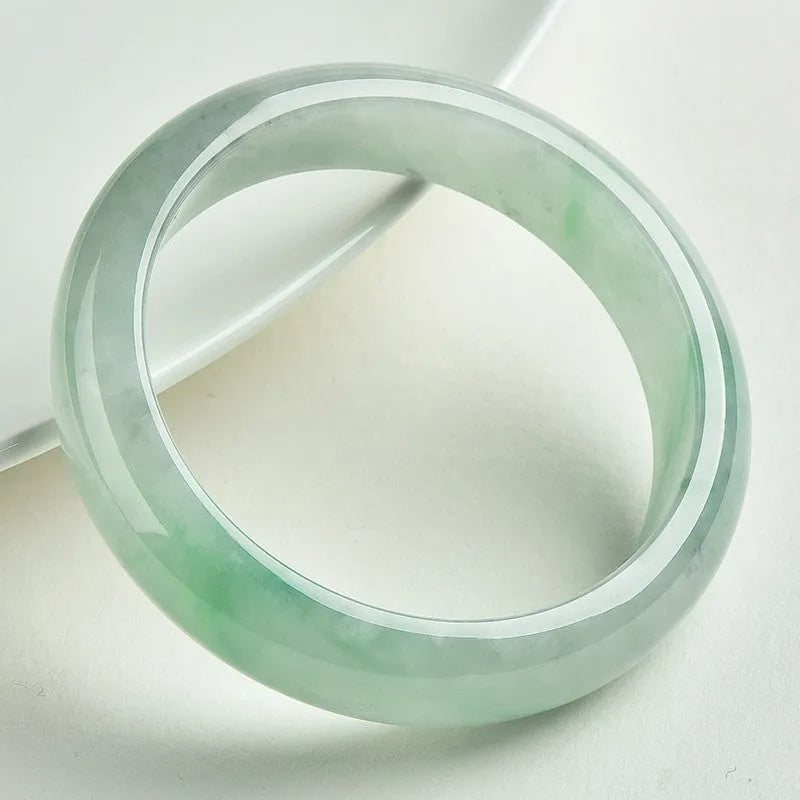 Light green jade bracelet on wrist showing natural stone texture and colour