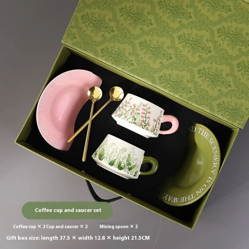 Ceramic coffee cup and saucer set for two with stirring spoons in couple's cup design.