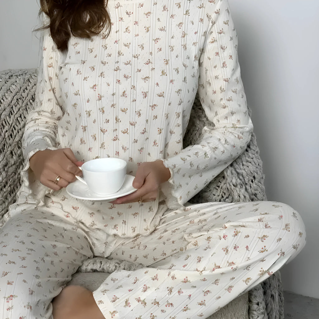 White women's floral print bell sleeve top and wide leg pants suit laid flat.