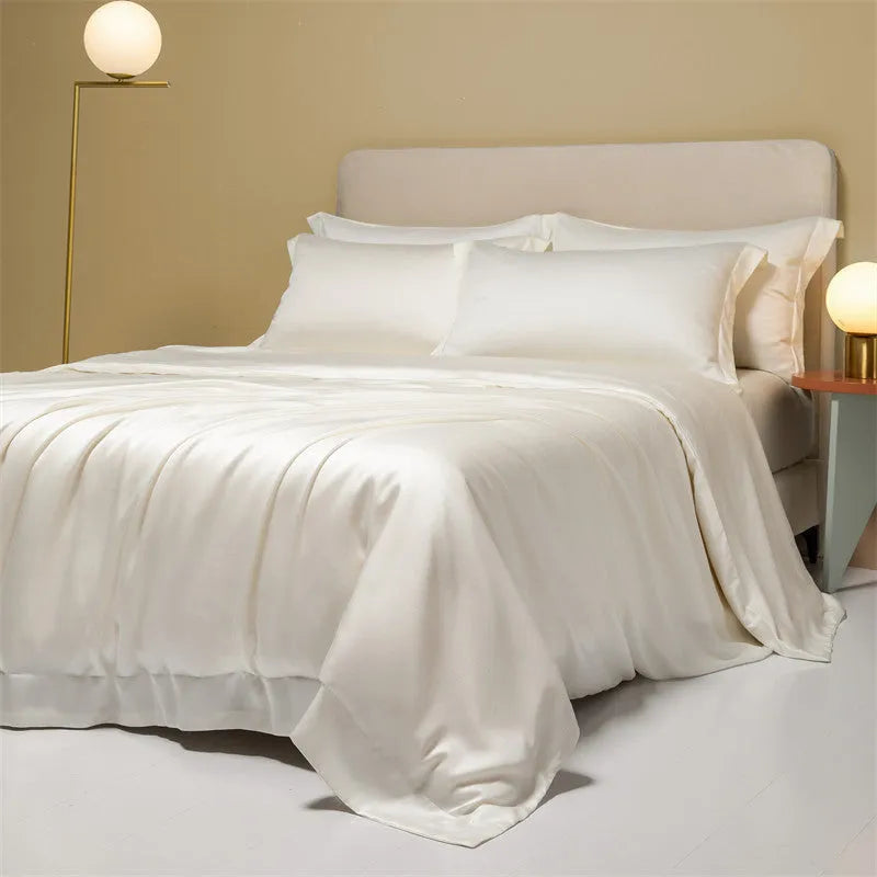 Luxury Lenzing Tencel bedding set in Aurora Blue on a bed, showing quilt cover, sheet, and two pillowcases.