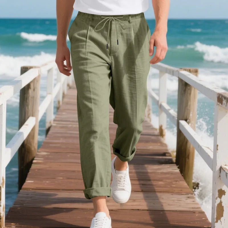 Man wearing light khaki linen casual trousers with a drawstring waist and straight-leg fit.