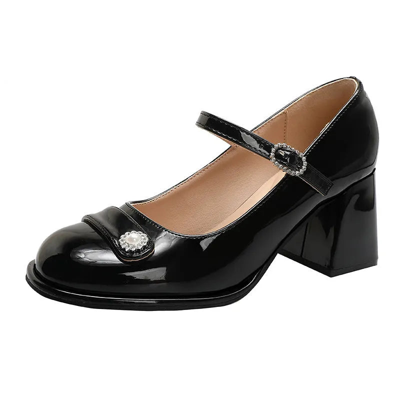 Women's black patent leather wide fit chunky heel shoe with round toe and buckle fastening.