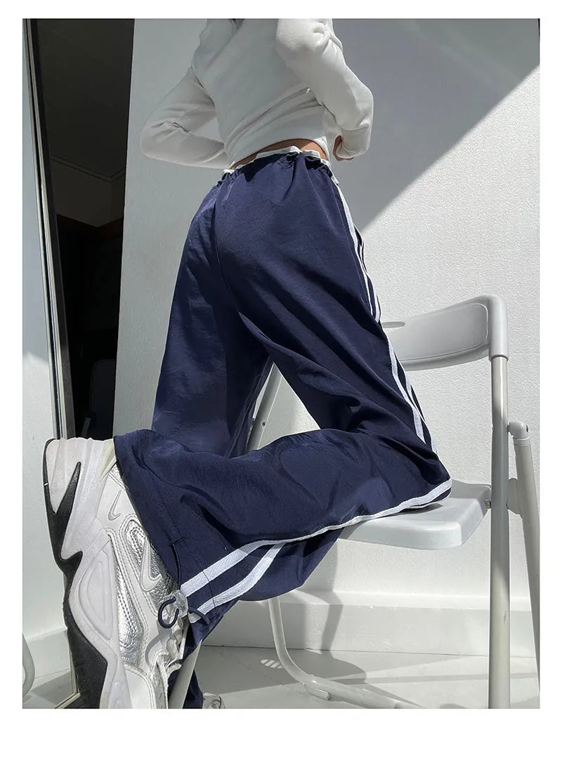 Women's navy blue straight-leg trousers with a white contrast ribbon detail sewn along the side seams.