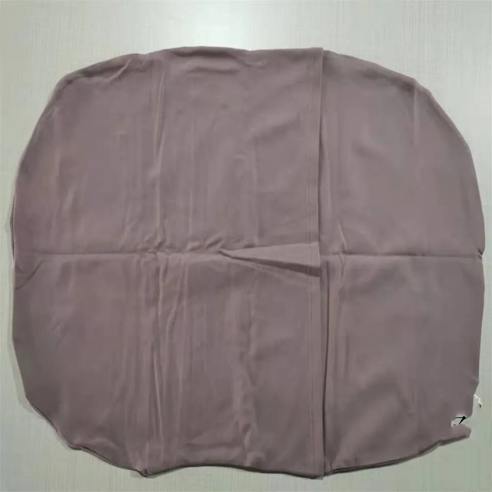 Beige portable baby nest cot crib for infants on a neutral background