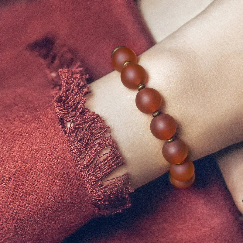 Retro ethnic style couples bracelet with green or red agate beads on a wrist.