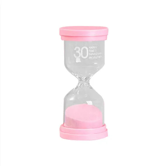 Handmade glass sand timer in blue colour showing sand flowing, on a wooden desk.