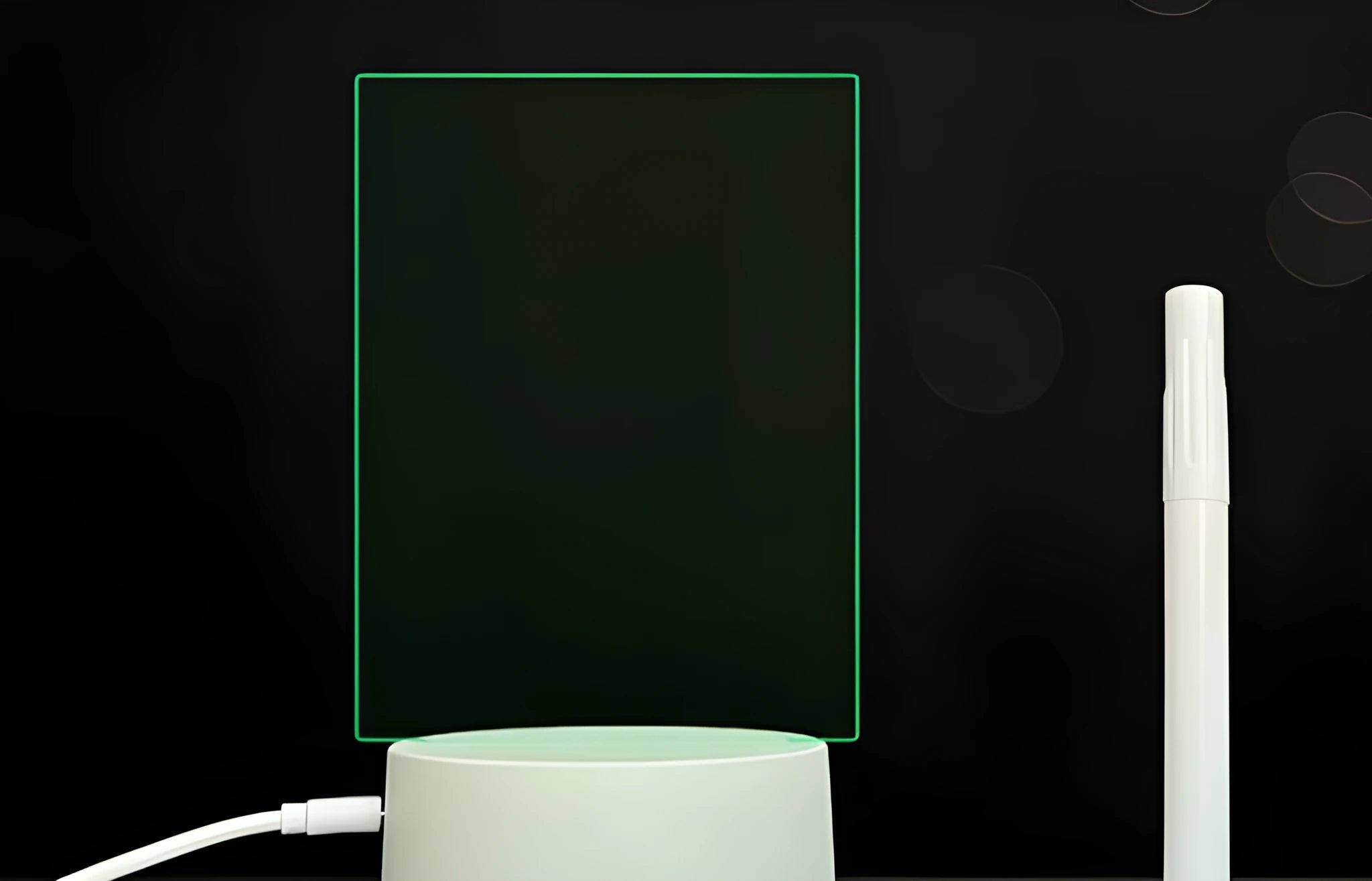 Black 3D acrylic message board night light with remote control and stylus on desk.