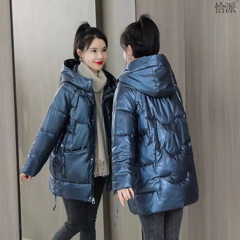 Women's loose fit hooded winter jacket in black, shown on a model, featuring a front zip and acrylic lining.