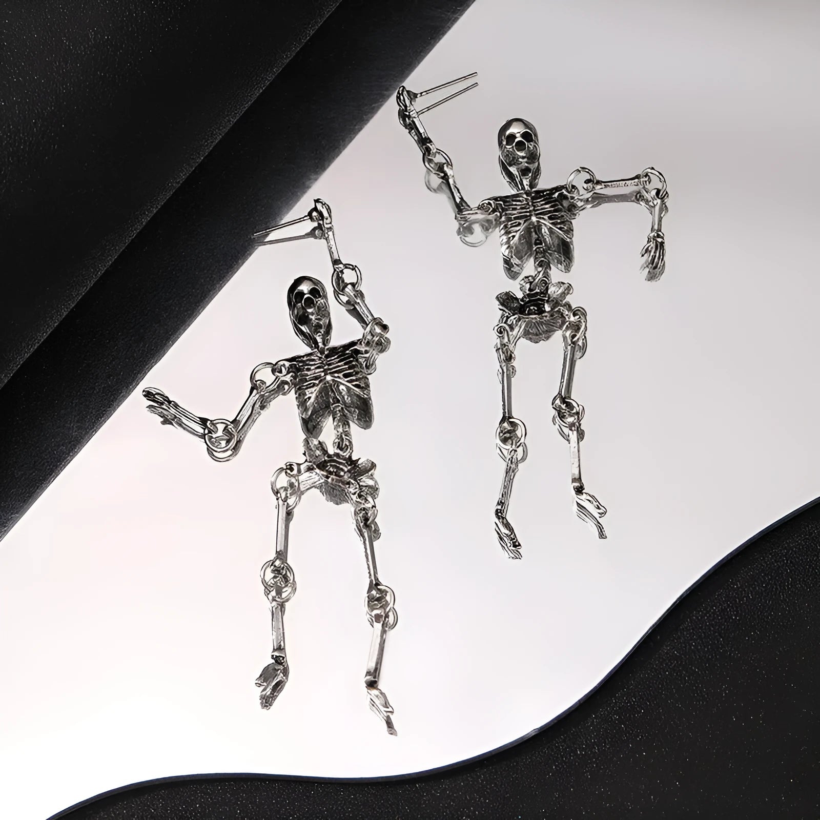 Exaggerated skull frame earrings in antique silver, zinc alloy electroplated finish, unisex design with hook fastening on white background