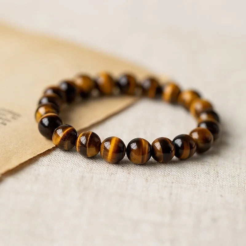 Single circle ethnic Tigereye bead Buddha rosary bracelet on a wrist, showing unisex design.