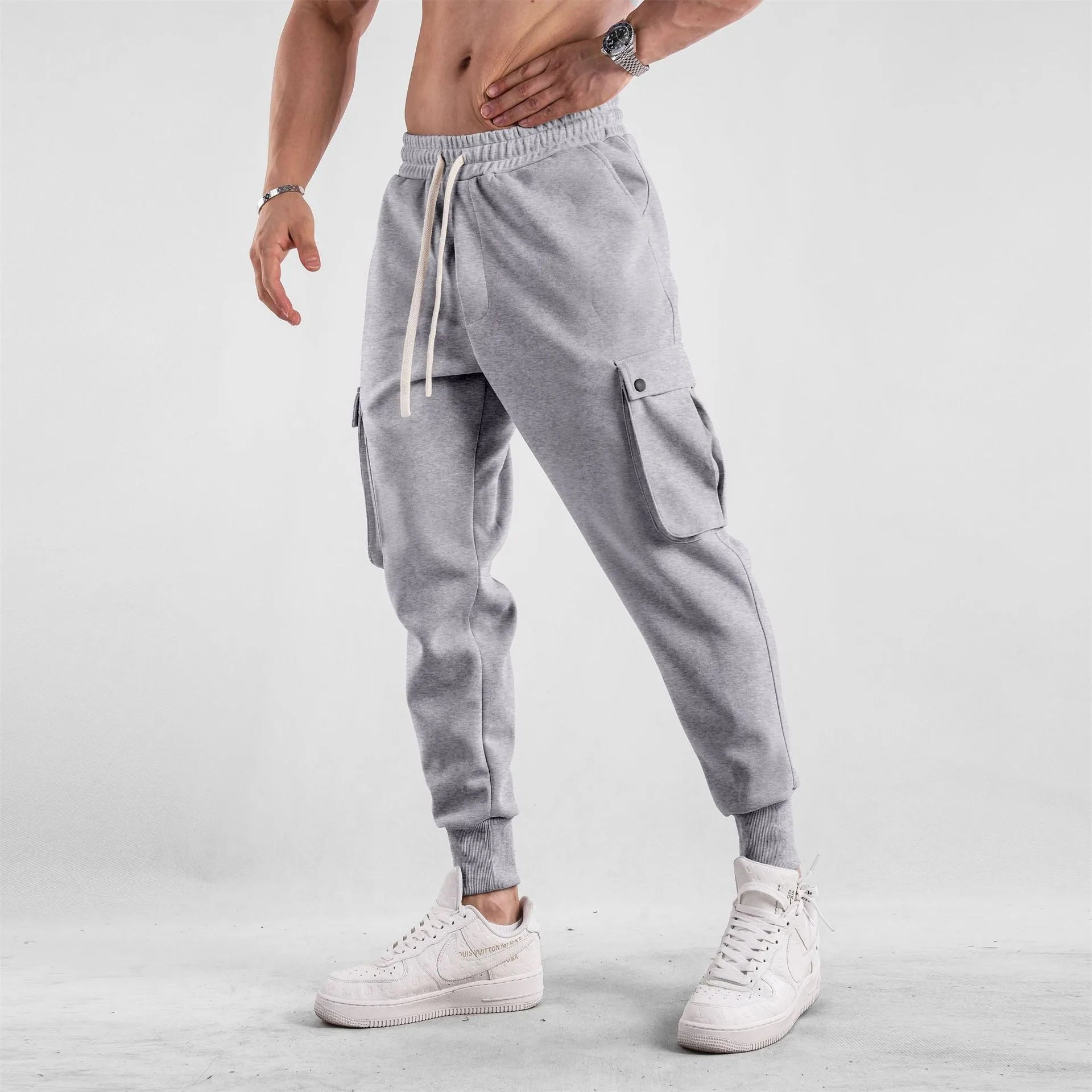 Men's loose-fit apricot coloured cotton sports trousers with an ankle tie and side pockets on a neutral background.