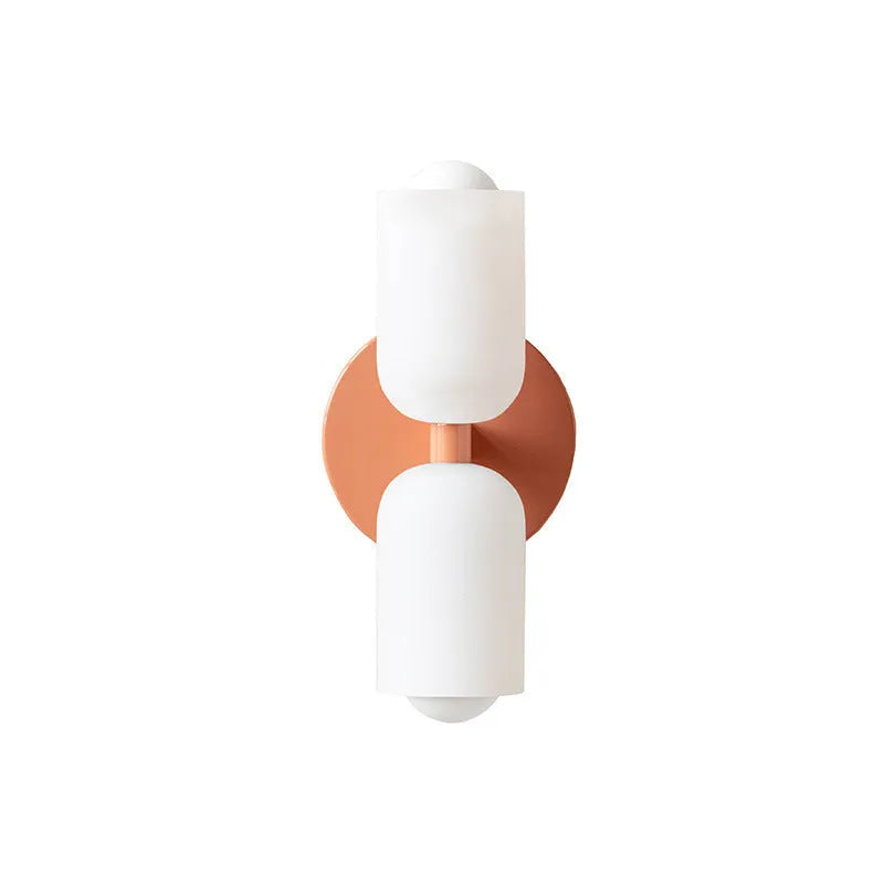 Cream base double head wall lamp with white glass shades against wall