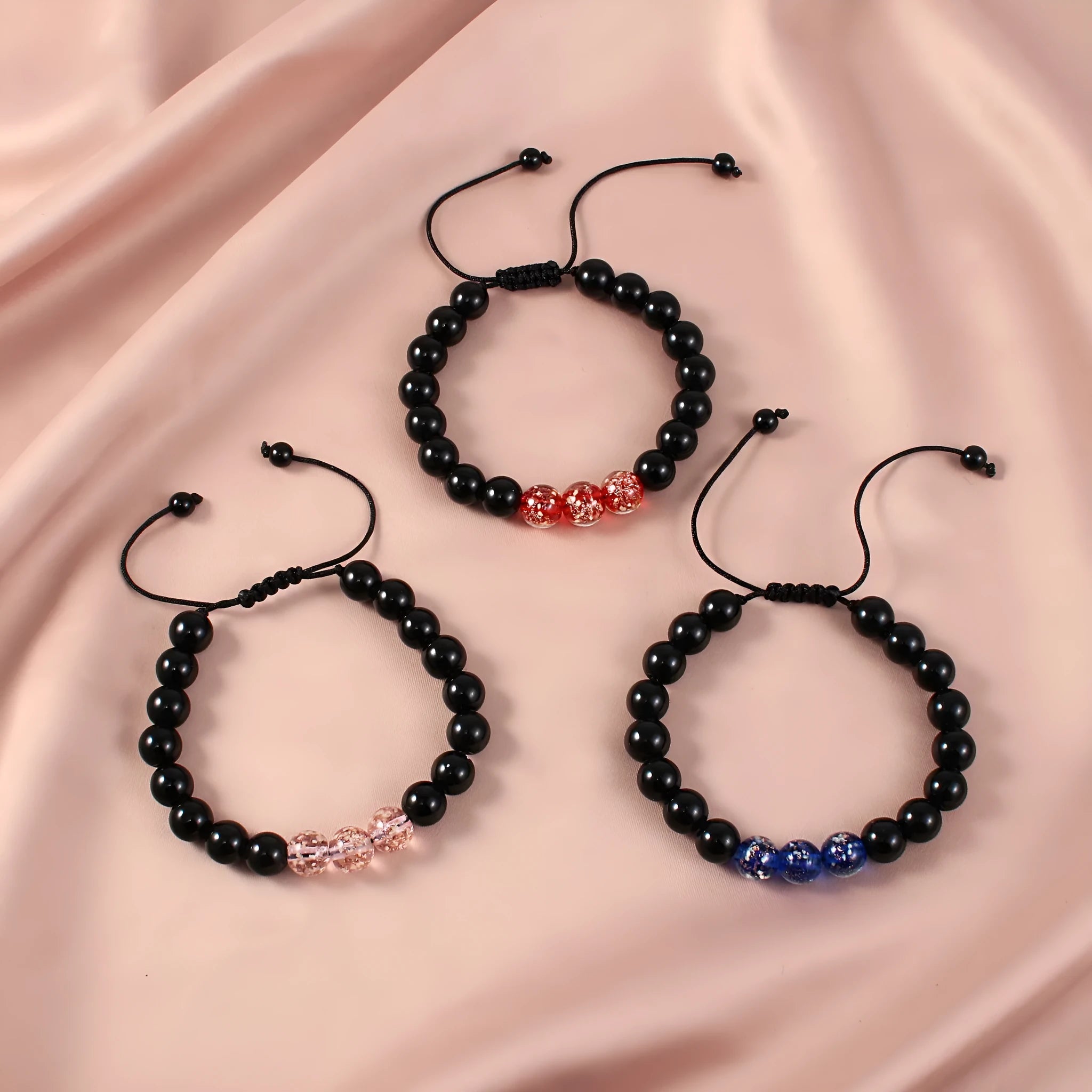 Adjustable luminous glass bead bracelet in geometric shapes on wrist showing elastic cord threading