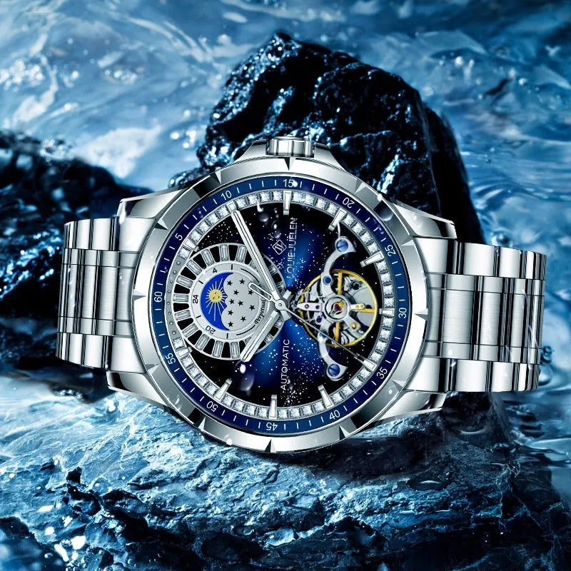 Men's silver automatic watch with blue dial on a stainless steel bracelet, showing transparent case back.