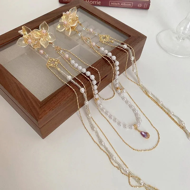 Gold-coloured acrylic hairpin with a long tassel and diamond-treated flower decoration.