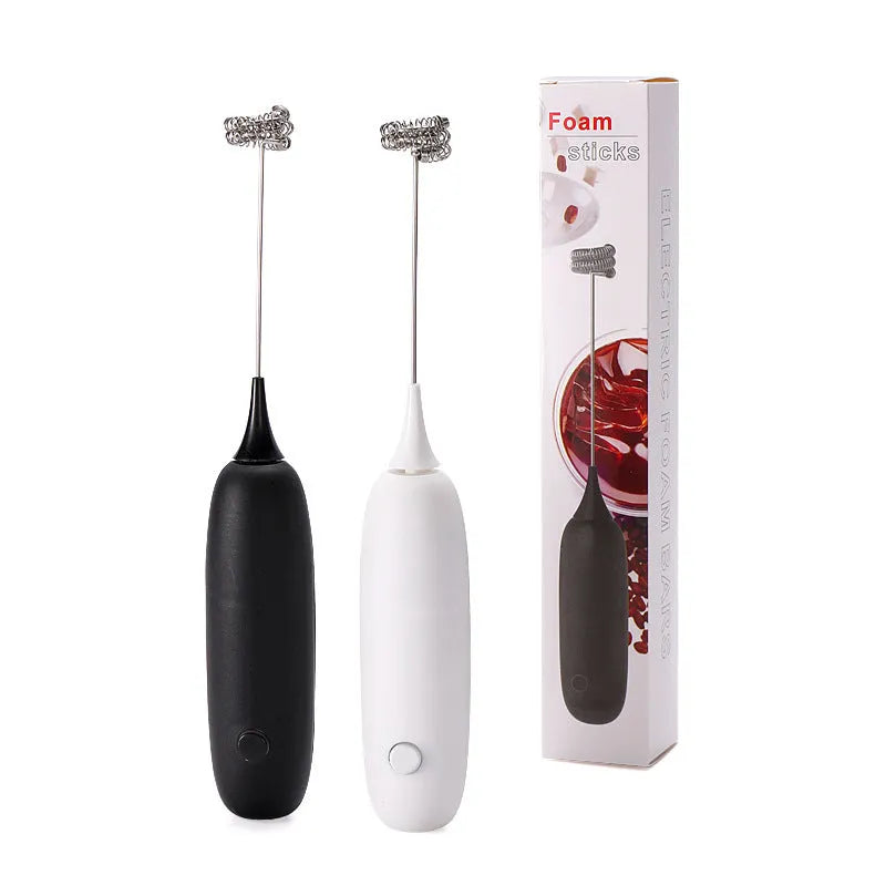A handheld electric milk frother and blender in black and white colours on a kitchen counter.