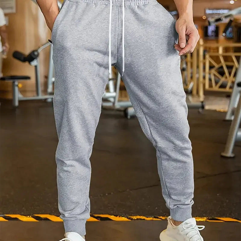 Men's linen-coloured leisure trousers with a loose fit and drawstring waist.