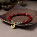 Handmade gold cinnabar wave bracelet showing genuine stone and copper bead construction in national style design