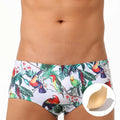 Men's blue swimming trunks with a detailed floral and bird print pattern, small boxer style