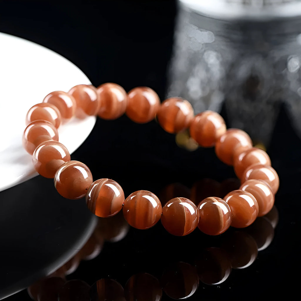 Natural Old Mine Rhodochrosite round bead bracelet with Ruyi element, shown in 6mm and 8mm sizes.