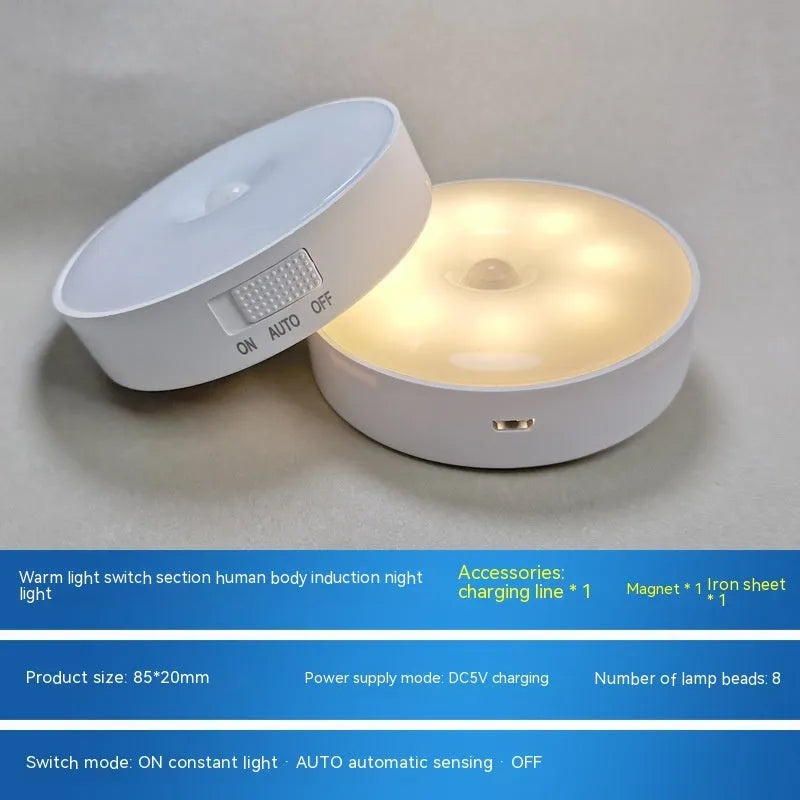 Compact round beige motion sensor LED night light with USB charging cable on a wooden surface