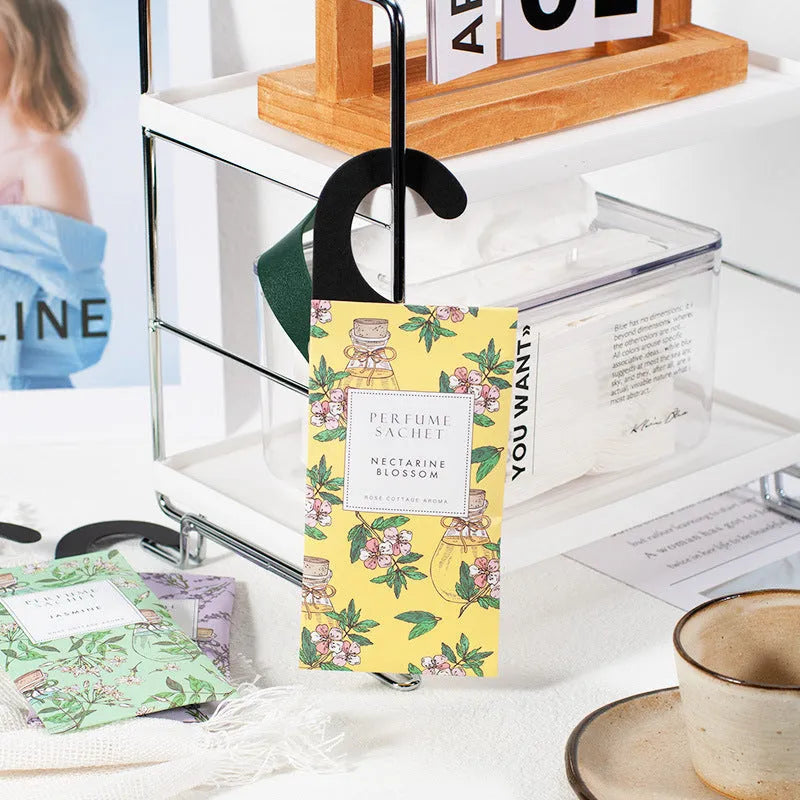 Pack of five household wardrobe sachets with lavender, rose, jasmine, sandalwood, vanilla, apricot blossom aromas on a shelf