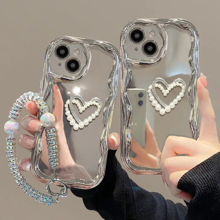 Silver grey silicone phone case for iPhone 14 Pro Max with three-dimensional heart and pearl chain bracelet.