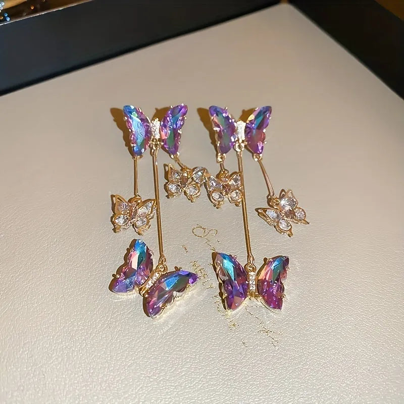 Silver Needle Crystal Flowers Blue Purple Butterfly Tassel Drop Earrings on a white background.