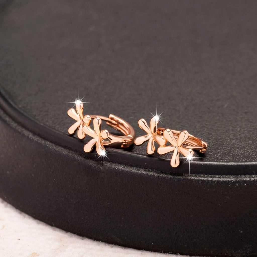 Circular rose gold earrings with a waterdrop flower pattern, shown front-on.